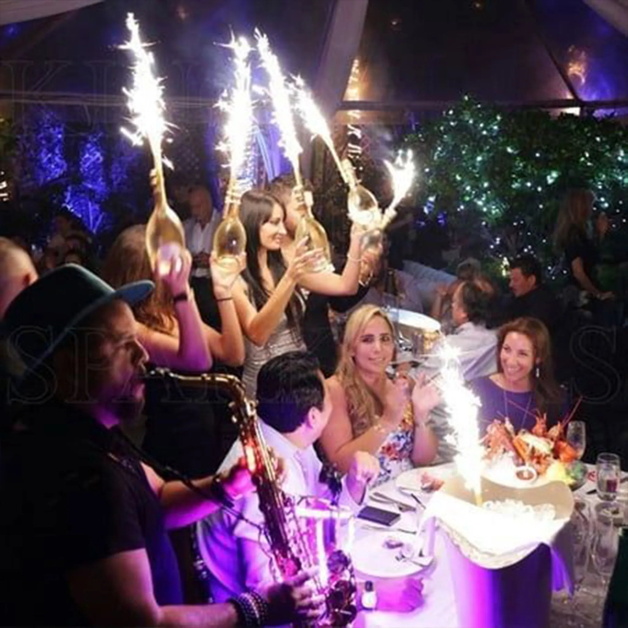 People celebrating with bottle sparklers at a festive event