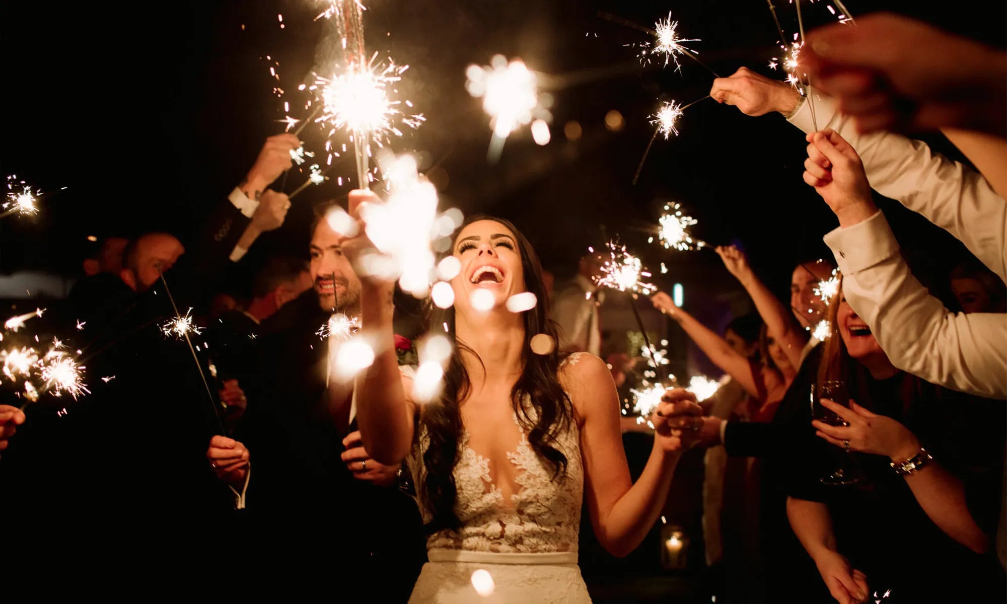 Couple exits in a wedding sparklers send off with no smoke in picture